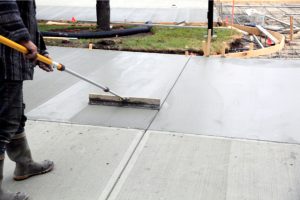 Concrete Preparation by worker with a broom